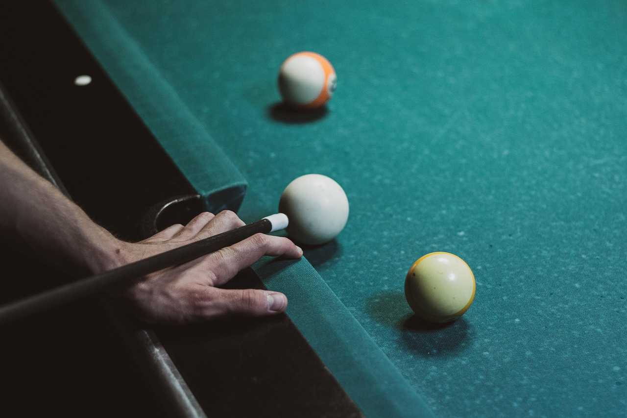 Main jouant au billard sur table verte